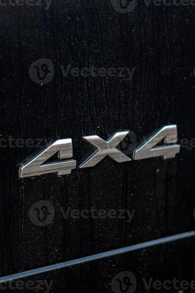 Grunge track 4x4 letters. The designation of all-wheel drive on SUVs. Unique off-road inscription in silver on a black back. photo