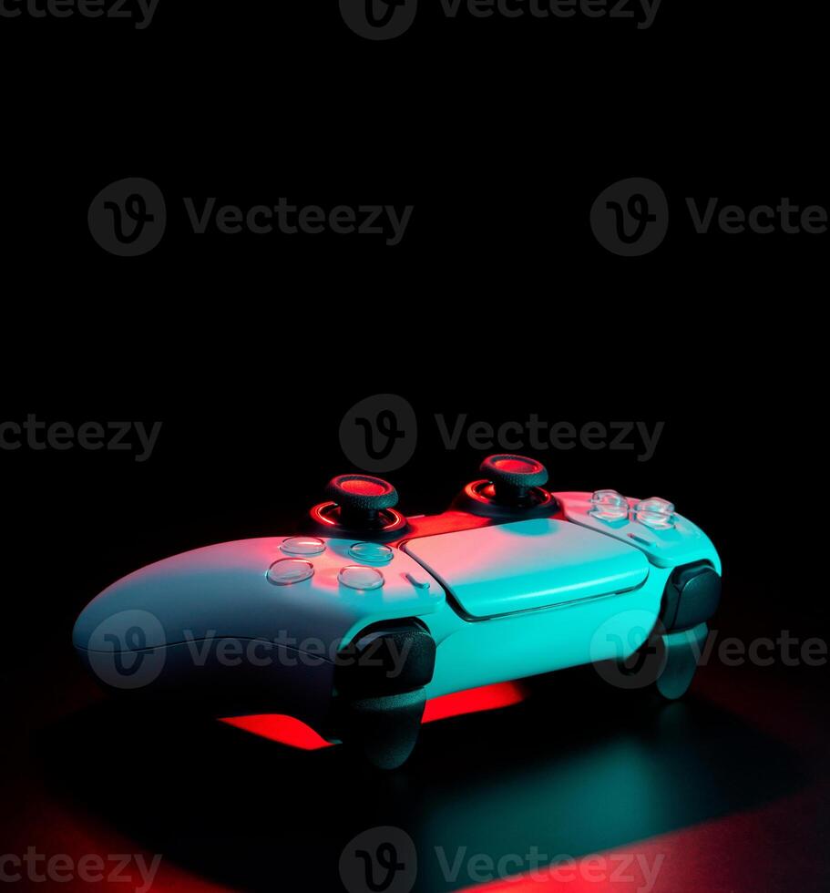 Modern white gamepad illuminated in red and blue. Game controller for games and e-sports on a dark back. photo