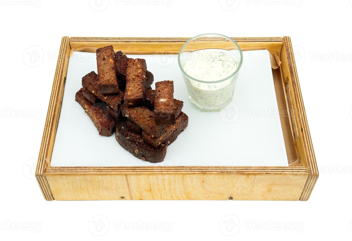 Black garlic bread snack. Fried Garlic croutons on white concrete table. Isolate on a white back photo