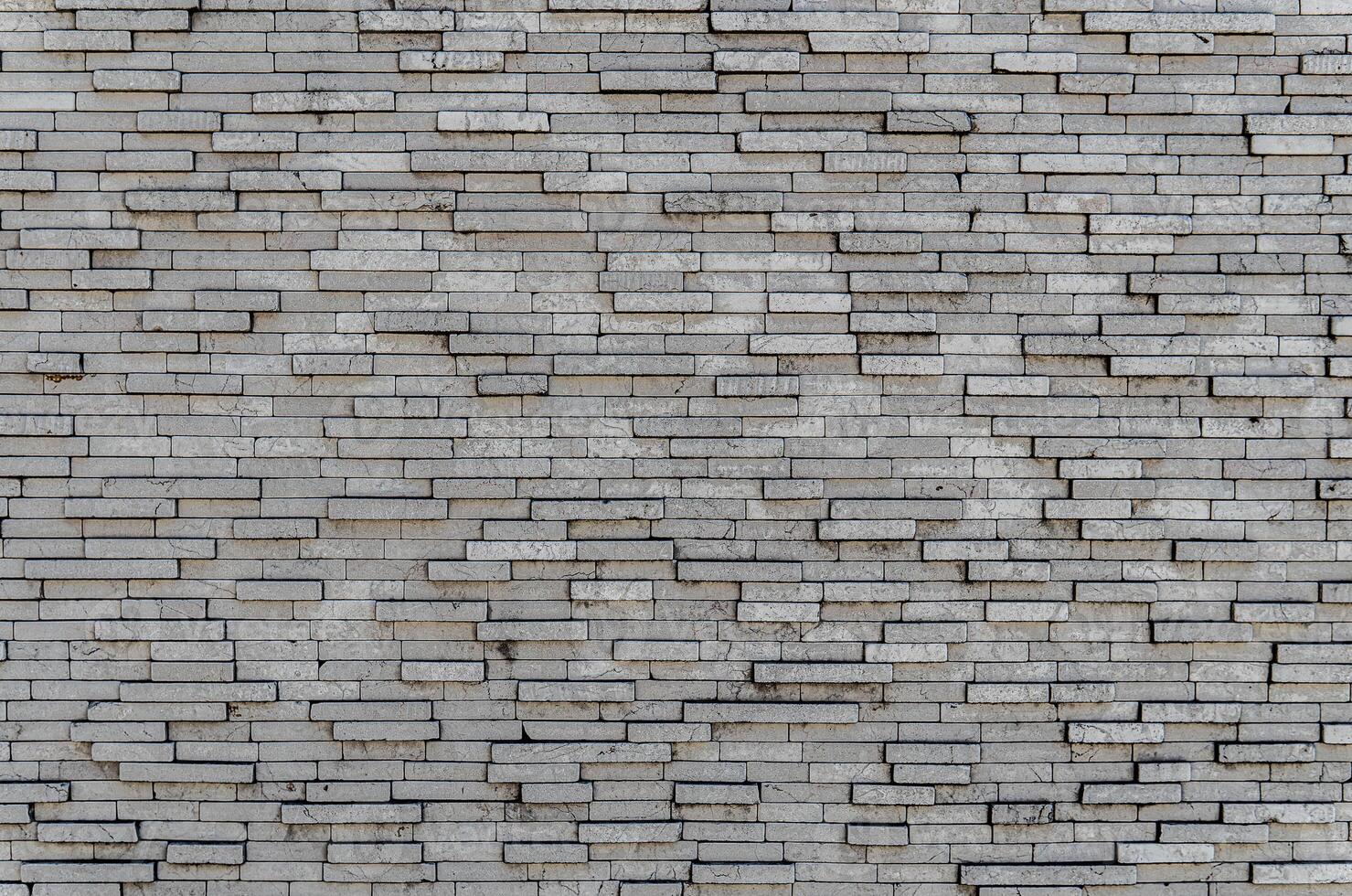Gray brick wall. Background of rectangular gray tiles of different sizes. photo