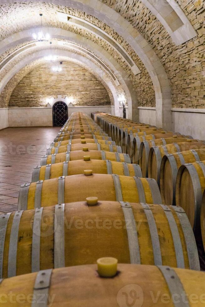 Wine barrels stacked in the cellar of the winery. Wine barrels in wine-vaults. photo