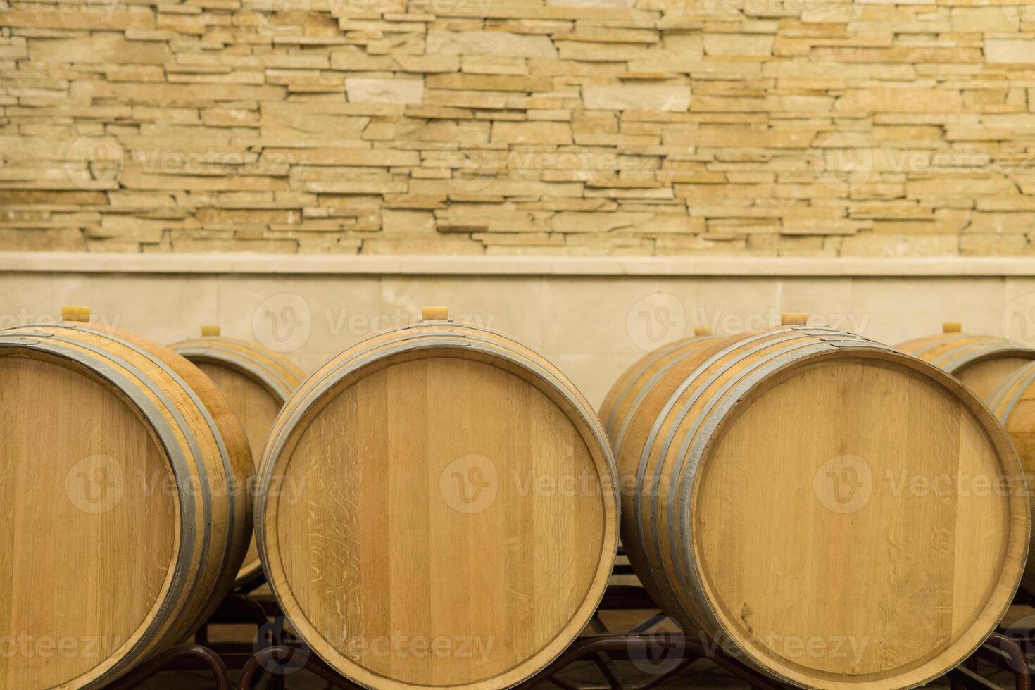 Wine barrels stacked in the cellar of the winery. Wine barrels in wine-vaults. photo
