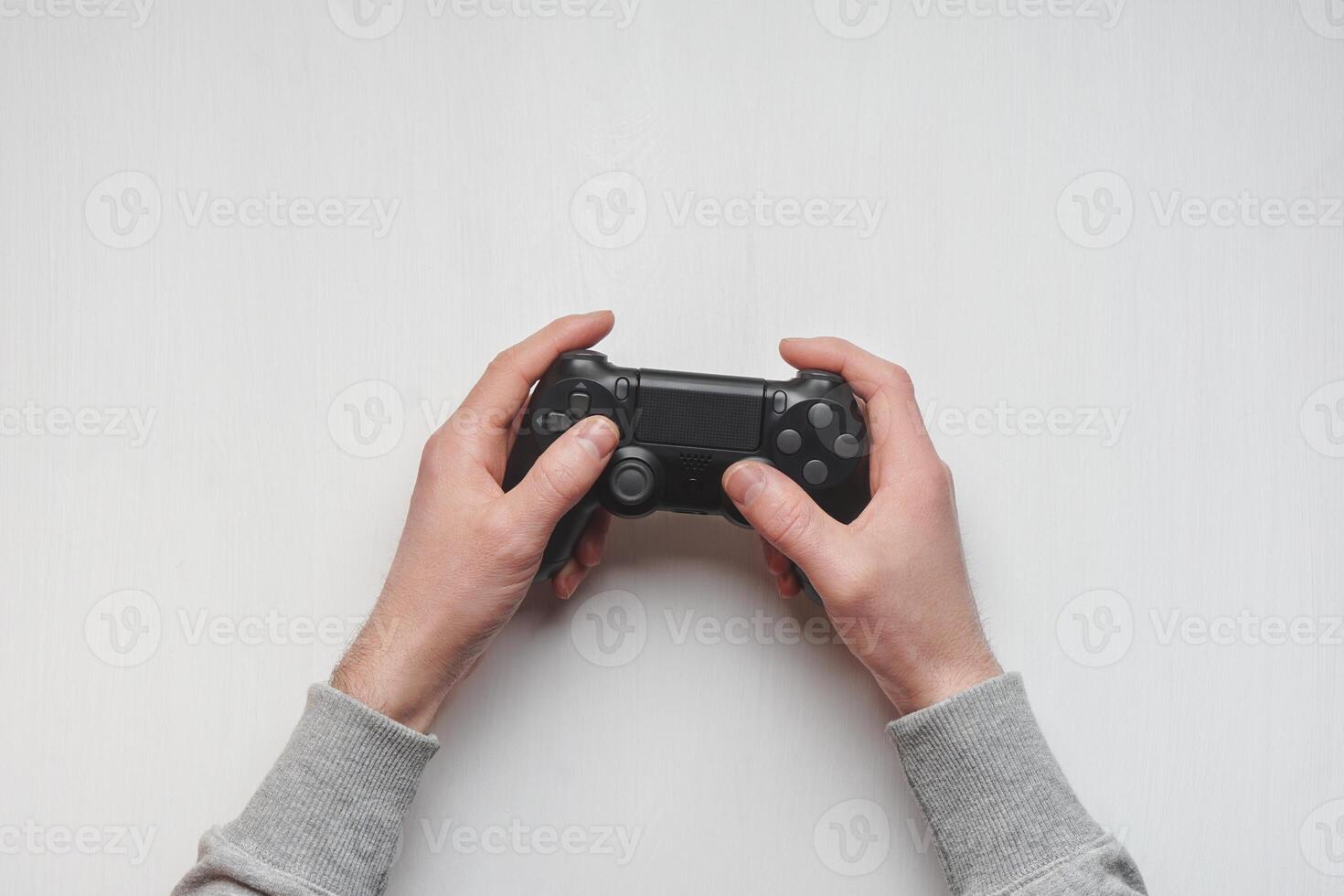Hand hold new joystick isolated. Gamer play game with gamepad controller. Gaming man holding simulator joypad. Person with keypad joystic in arms. Sleeve hands hold toy equipment. Modern manipulator. photo