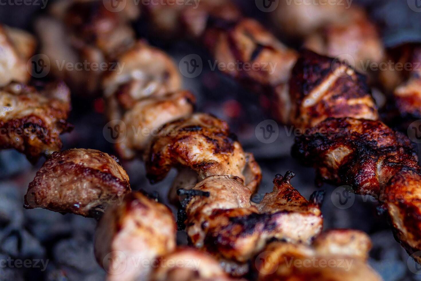 Fresh shish kebab on skewers is fried on the grill. Grilled meat on skewers. photo