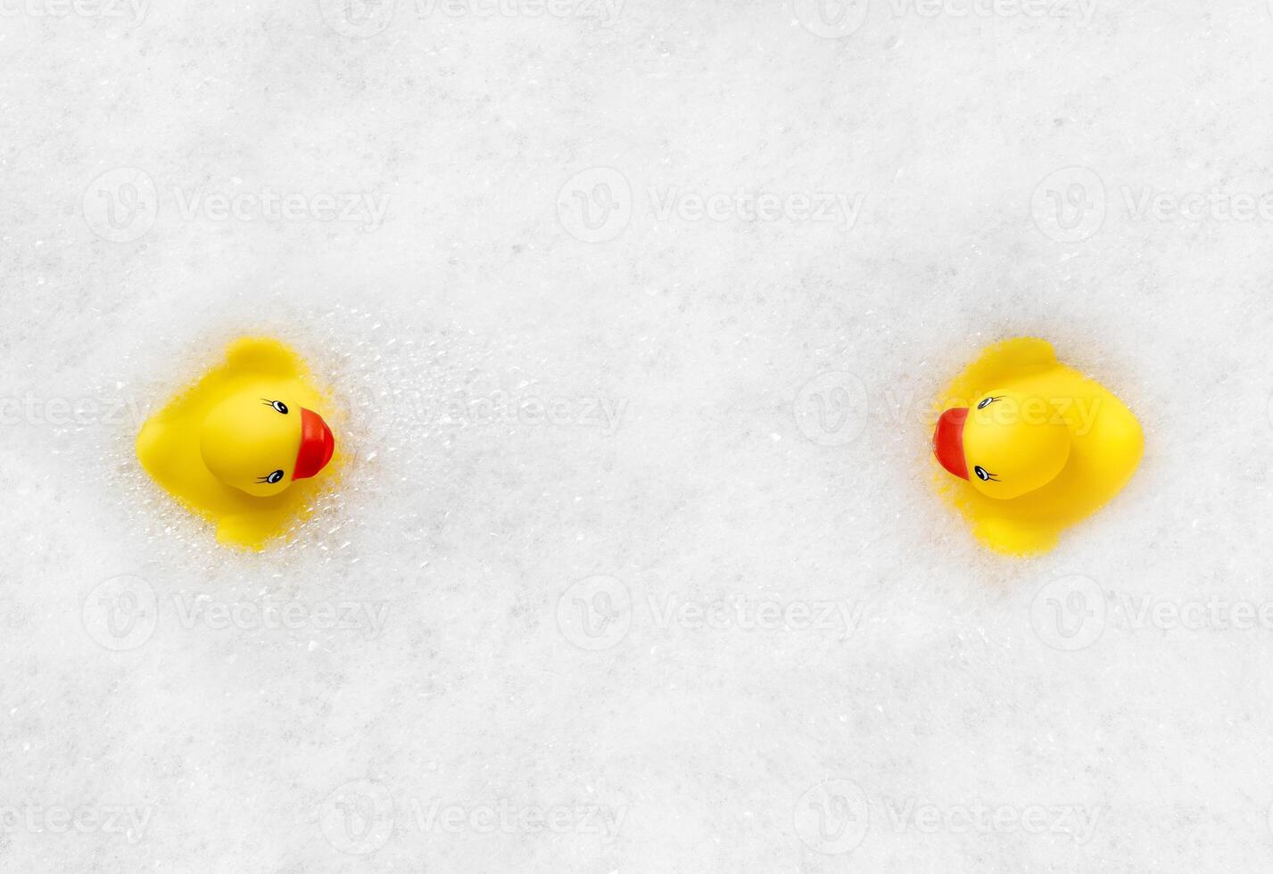 High Angle View of yellow rubber duck in bath swimming in foam water. Yellow rubber ducklings in soapy foam. photo