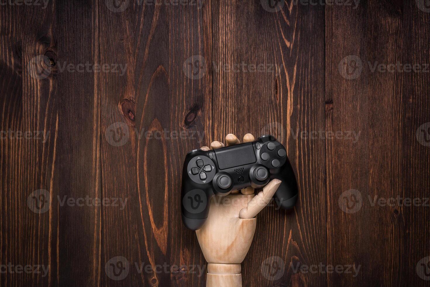 Modern black gamepad on a dark wooden background. Game concept with copy space for text. photo