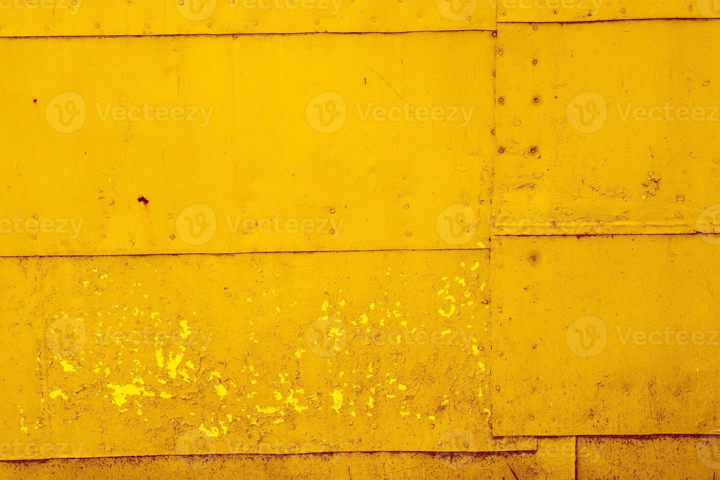Yellow textural background of old rusty metal sheets fastened together with rivets and nails. photo