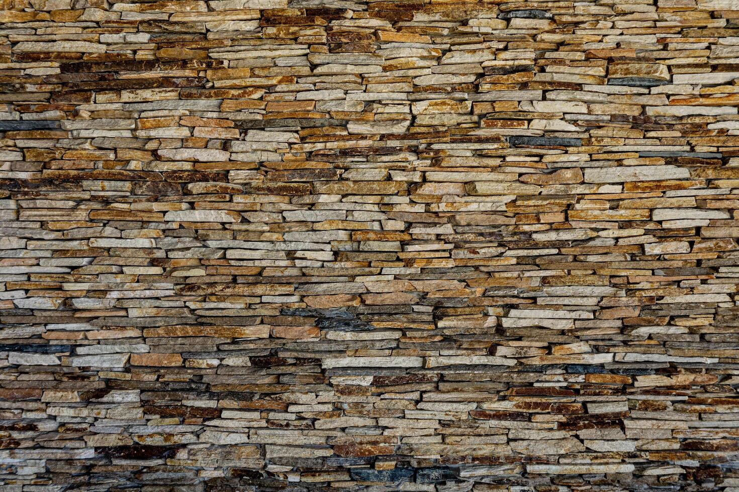 Wall of stone slate. Pattern of decorative slate stone wall surface. A wall of natural flat stones. Texture for background. Many slate tiles on a wall creating an interresting texture. photo