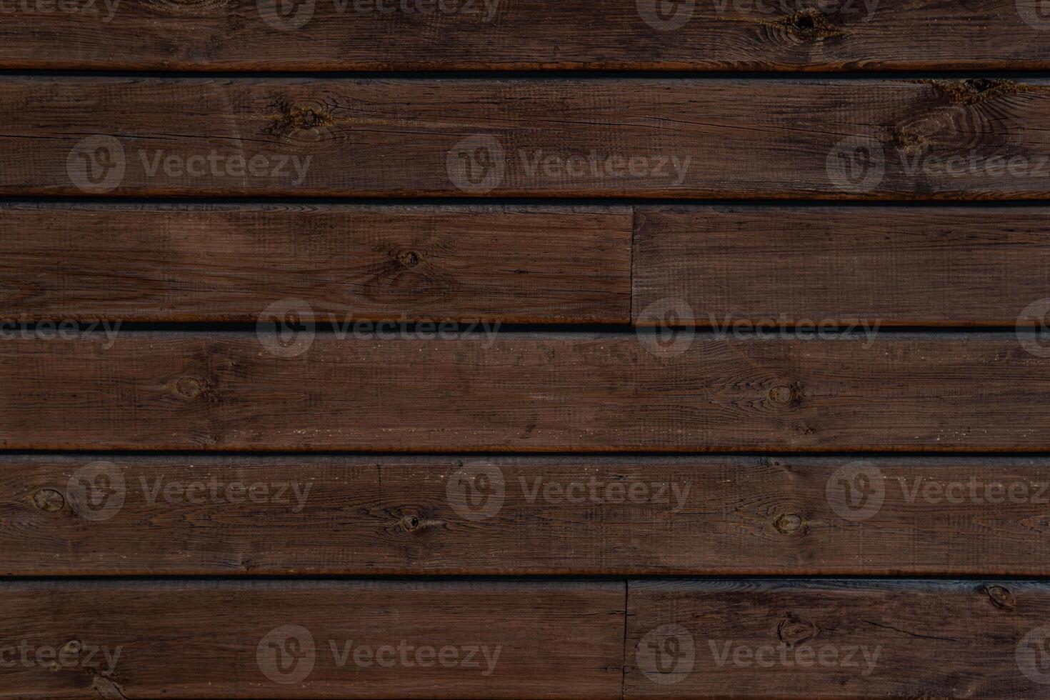Medium brown wood texture backviewed from above. The wooden planks are stacked horizontally and have a worn look. photo