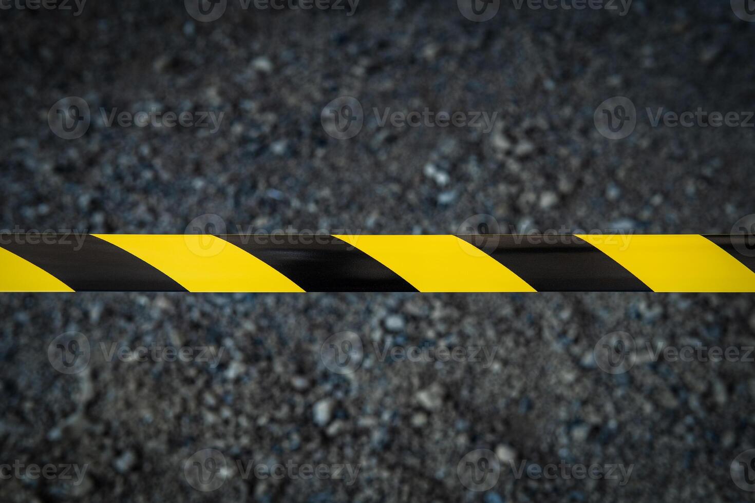 Black and yellow striped tapes on dark back. Restricted area border. Passage is forbidden. photo