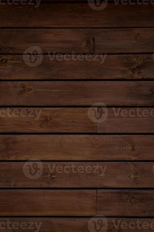 Medium brown wood texture backviewed from above. The wooden planks are stacked horizontally and have a worn look. photo