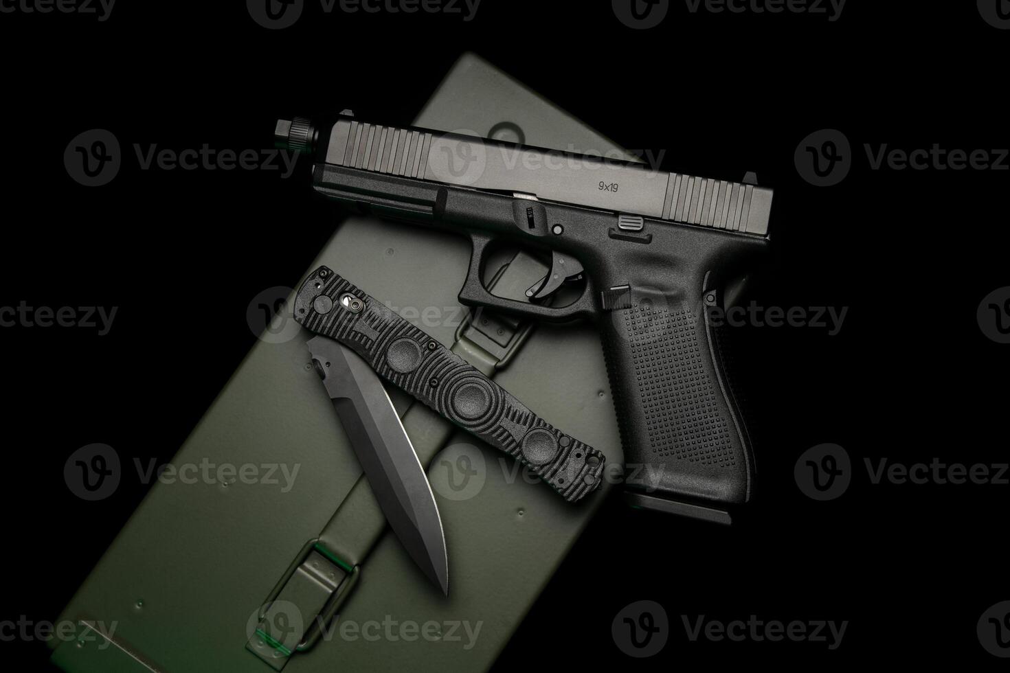 Modern semi-automatic pistol. A short-barreled weapon for self-defense. Folding penknife. Arming the police, special units and the army. Dark back photo