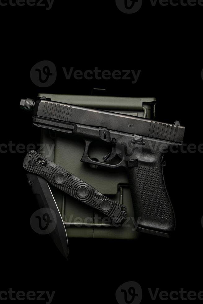 Modern semi-automatic pistol. A short-barreled weapon for self-defense. Folding penknife. Arming the police, special units and the army. Dark back photo