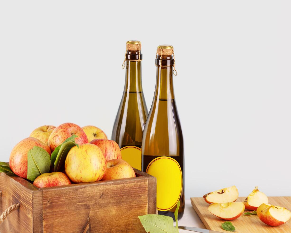Bottles with cider and apples in a wooden box photo