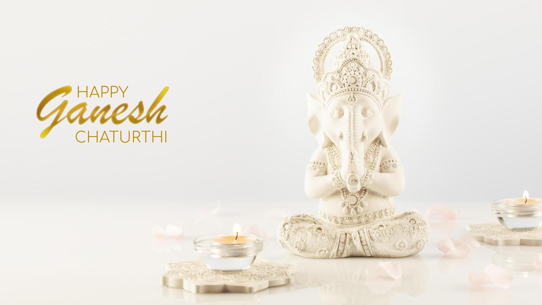 Greeting card with sculpture of ganesha with rose petals and candles photo