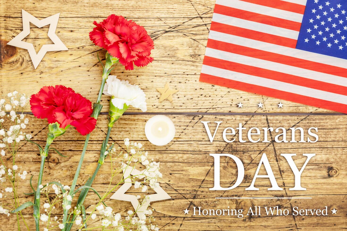 Carnations, candles and American flag on a wooden background photo