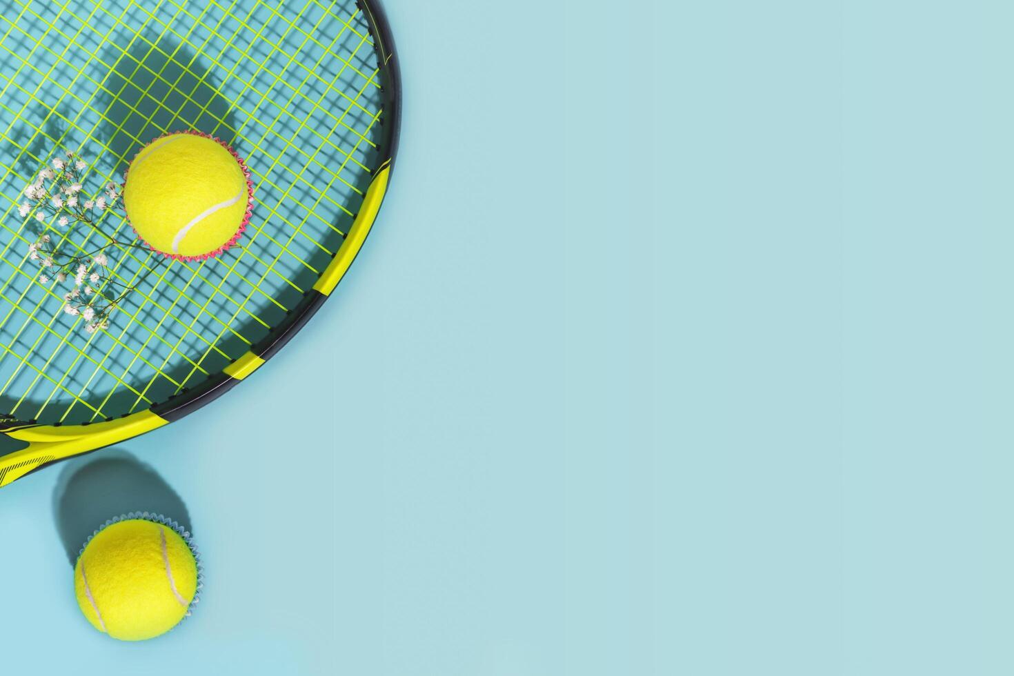 Yellow tennis balls and racket on a blue background with copy space photo