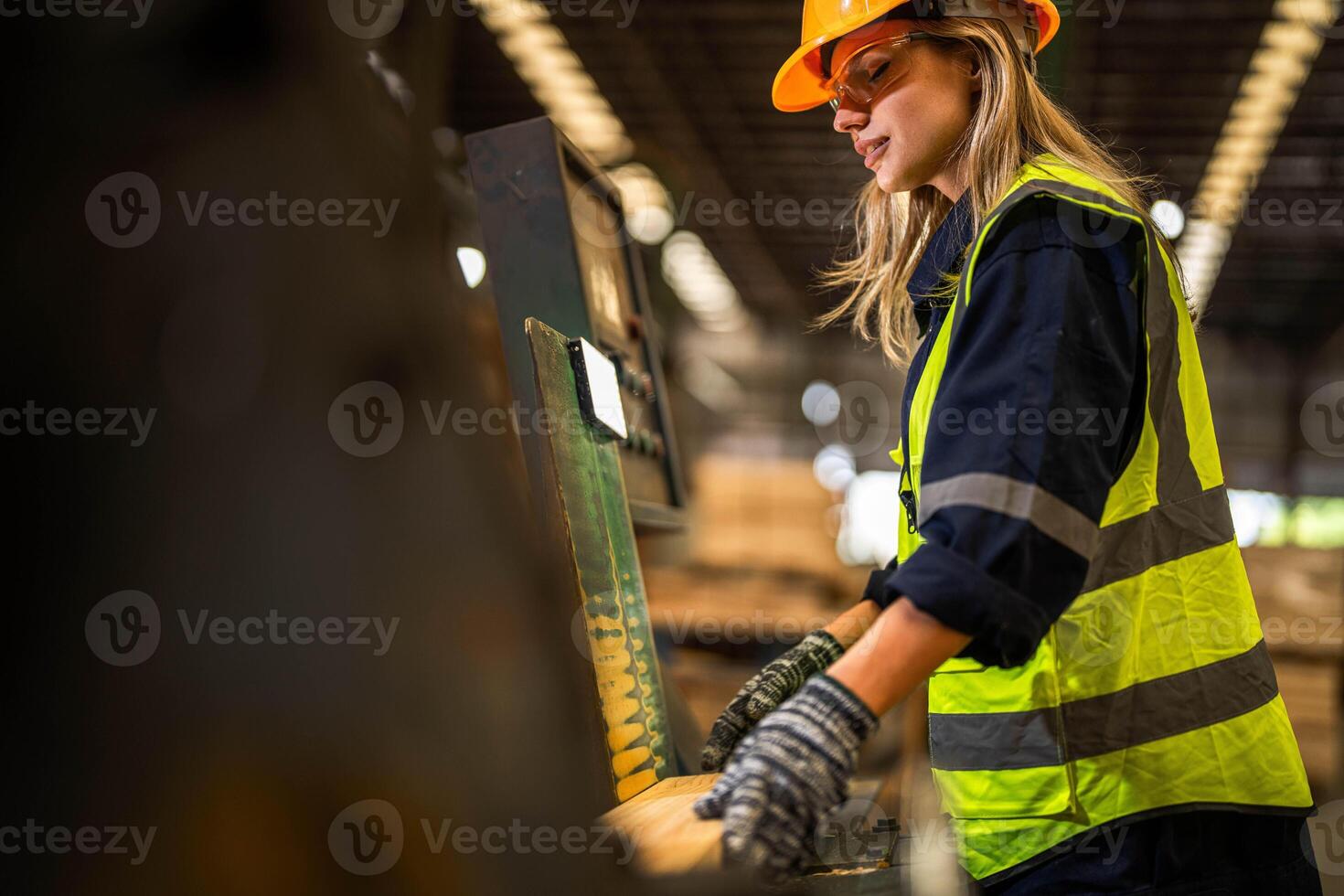 Factory engineer woman standing confident to control panel switch. Worker works at heavy machine at industry factory. worker checking timber of raw wood material. smart industry worker operating. photo