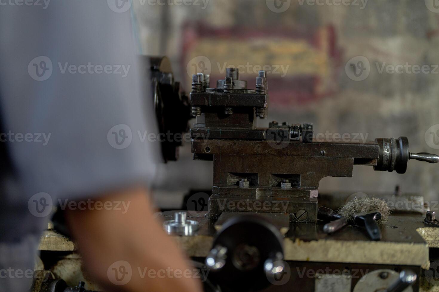 close up hand operation for Metal Lathes. steel column rolling in machine. metalworking industry. worker hand checks mechanic engine. Technician repairing drill bit on metal machine in factory photo