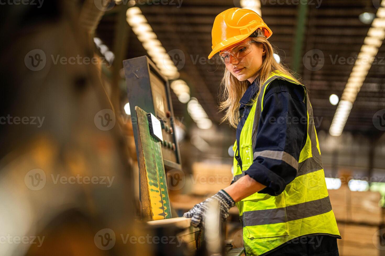 Factory engineer woman standing confident to control panel switch. Worker works at heavy machine at industry factory. worker checking timber of raw wood material. smart industry worker operating. photo