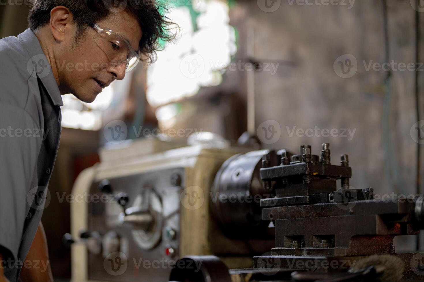 close up operation for Metal Lathes. The steel column rolling in machine. metalworking industry. worker hand checks mechanic engine. Technician repairing drill bit on metal machine in factory photo