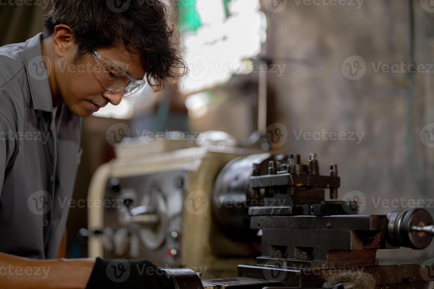 close up operation for Metal Lathes. The steel column rolling in machine. metalworking industry. worker hand checks mechanic engine. Technician repairing drill bit on metal machine in factory photo