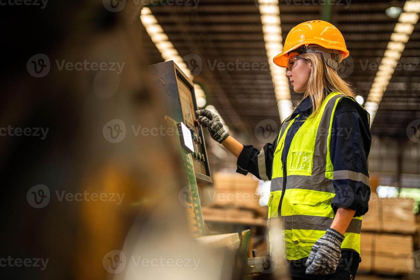 Factory engineer woman standing confident to control panel switch. Worker works at heavy machine at industry factory. worker checking timber of raw wood material. smart industry worker operating. photo