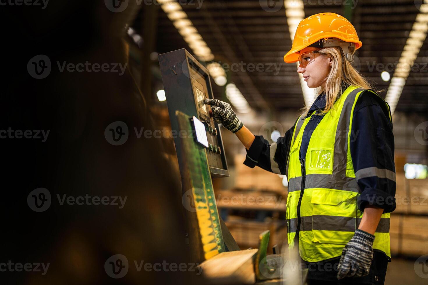 Factory engineer woman standing confident to control panel switch. Worker works at heavy machine at industry factory. worker checking timber of raw wood material. smart industry worker operating. photo