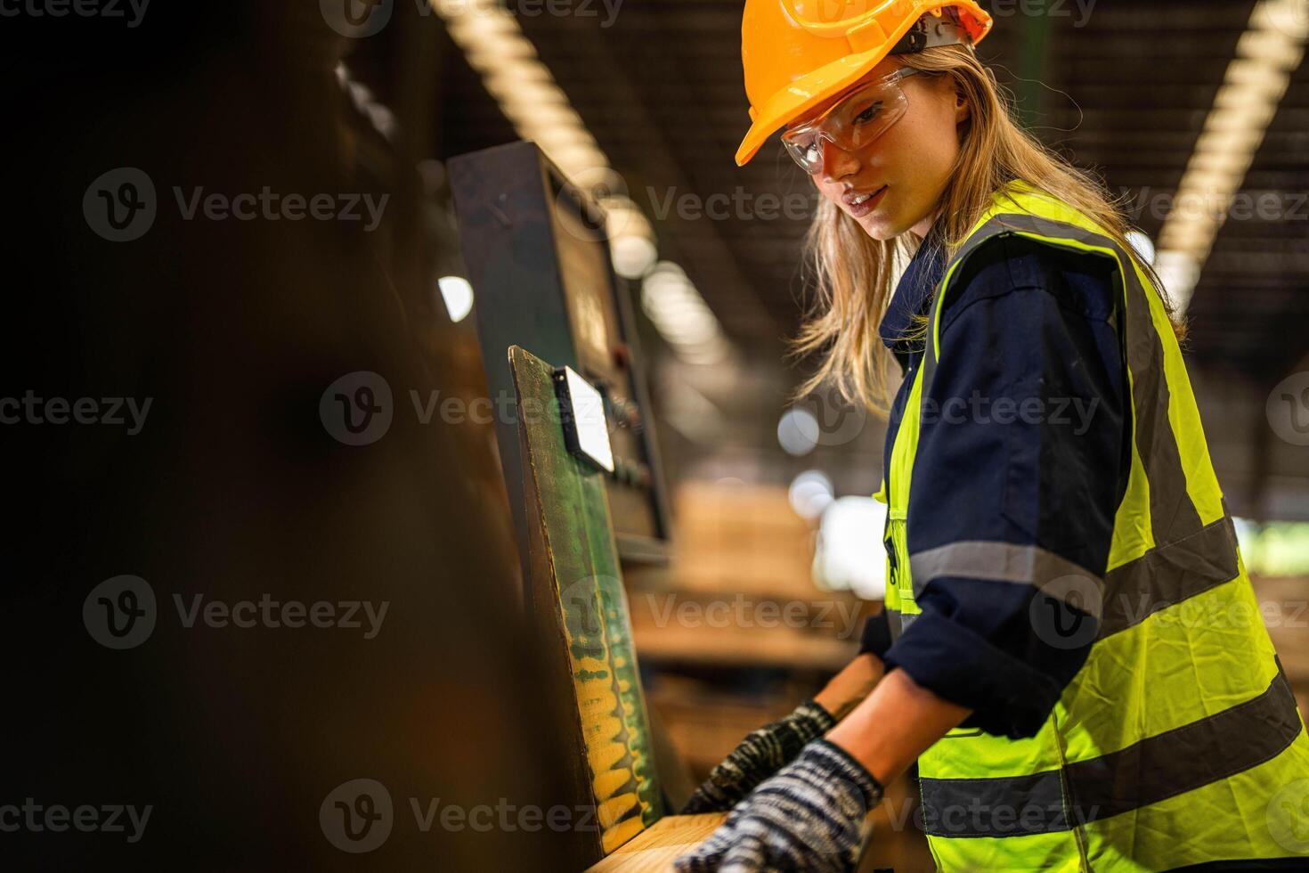 Factory engineer woman standing confident to control panel switch. Worker works at heavy machine at industry factory. worker checking timber of raw wood material. smart industry worker operating. photo
