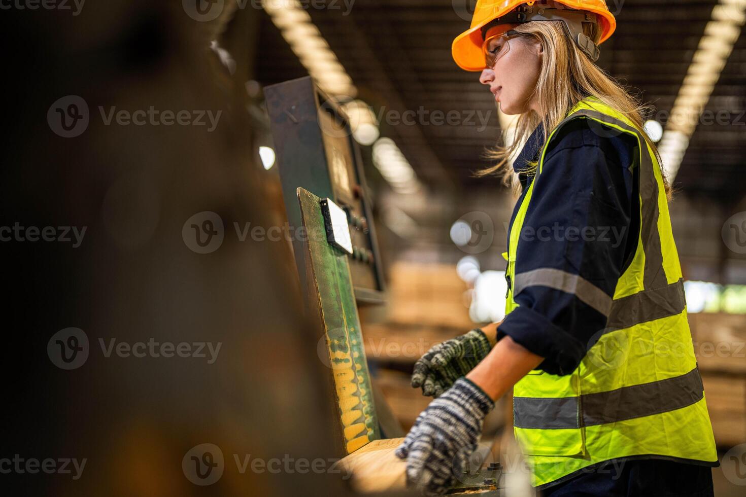 Factory engineer woman standing confident to control panel switch. Worker works at heavy machine at industry factory. worker checking timber of raw wood material. smart industry worker operating. photo