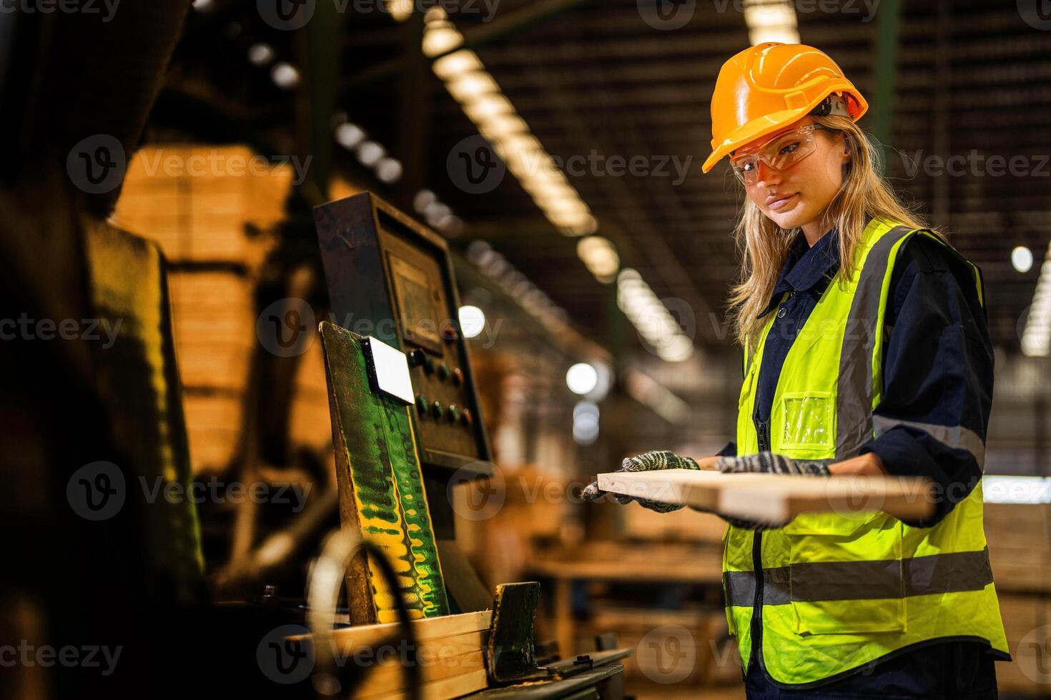 Factory engineer woman standing confident to control panel switch. Worker works at heavy machine at industry factory. worker checking timber of raw wood material. smart industry worker operating. photo