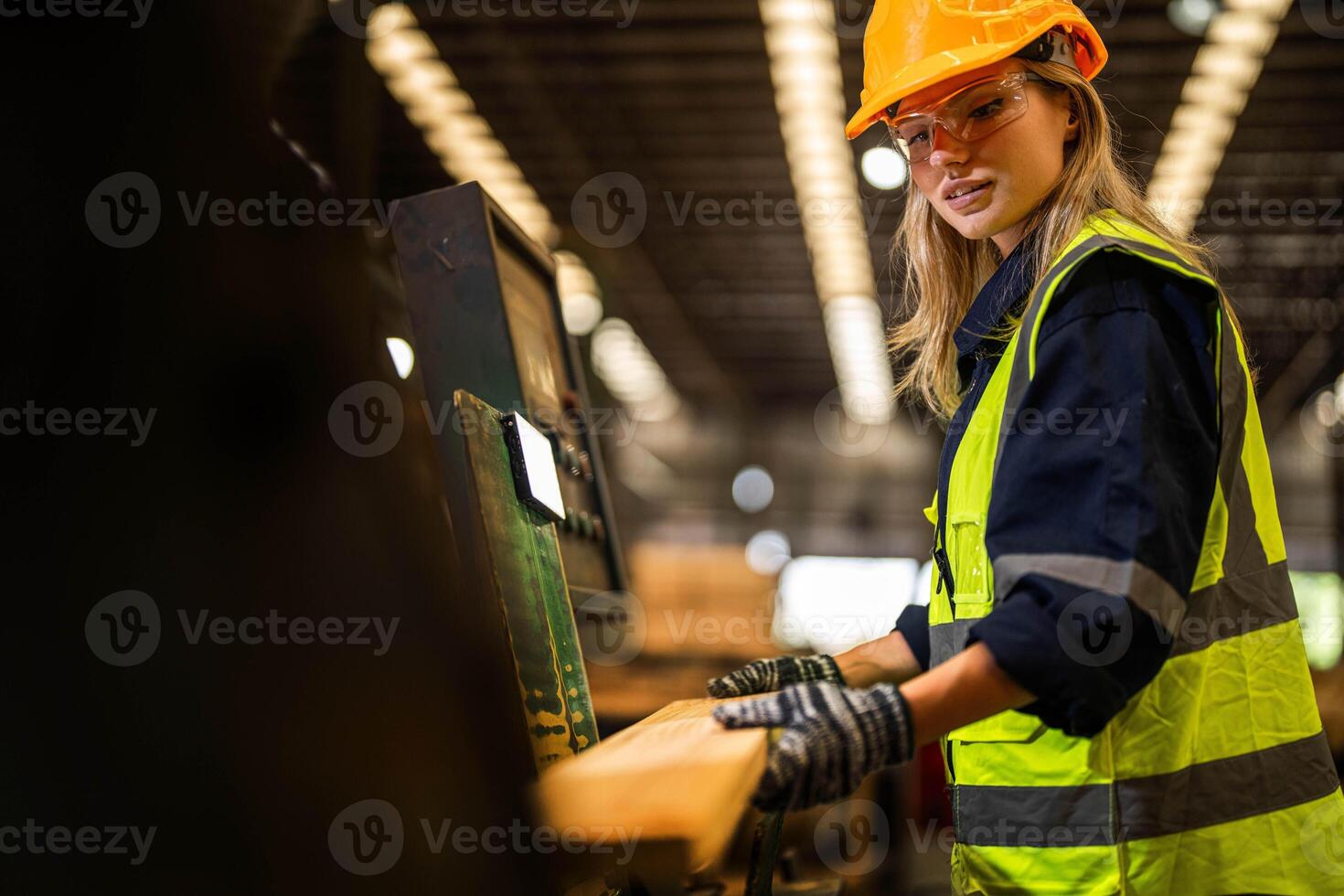 Factory engineer woman standing confident to control panel switch. Worker works at heavy machine at industry factory. worker checking timber of raw wood material. smart industry worker operating. photo