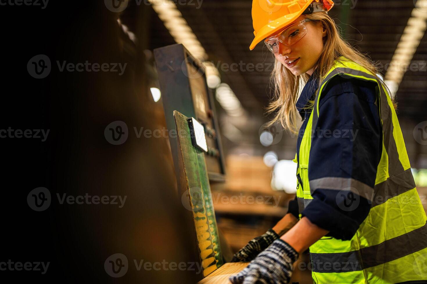 Factory engineer woman standing confident to control panel switch. Worker works at heavy machine at industry factory. worker checking timber of raw wood material. smart industry worker operating. photo