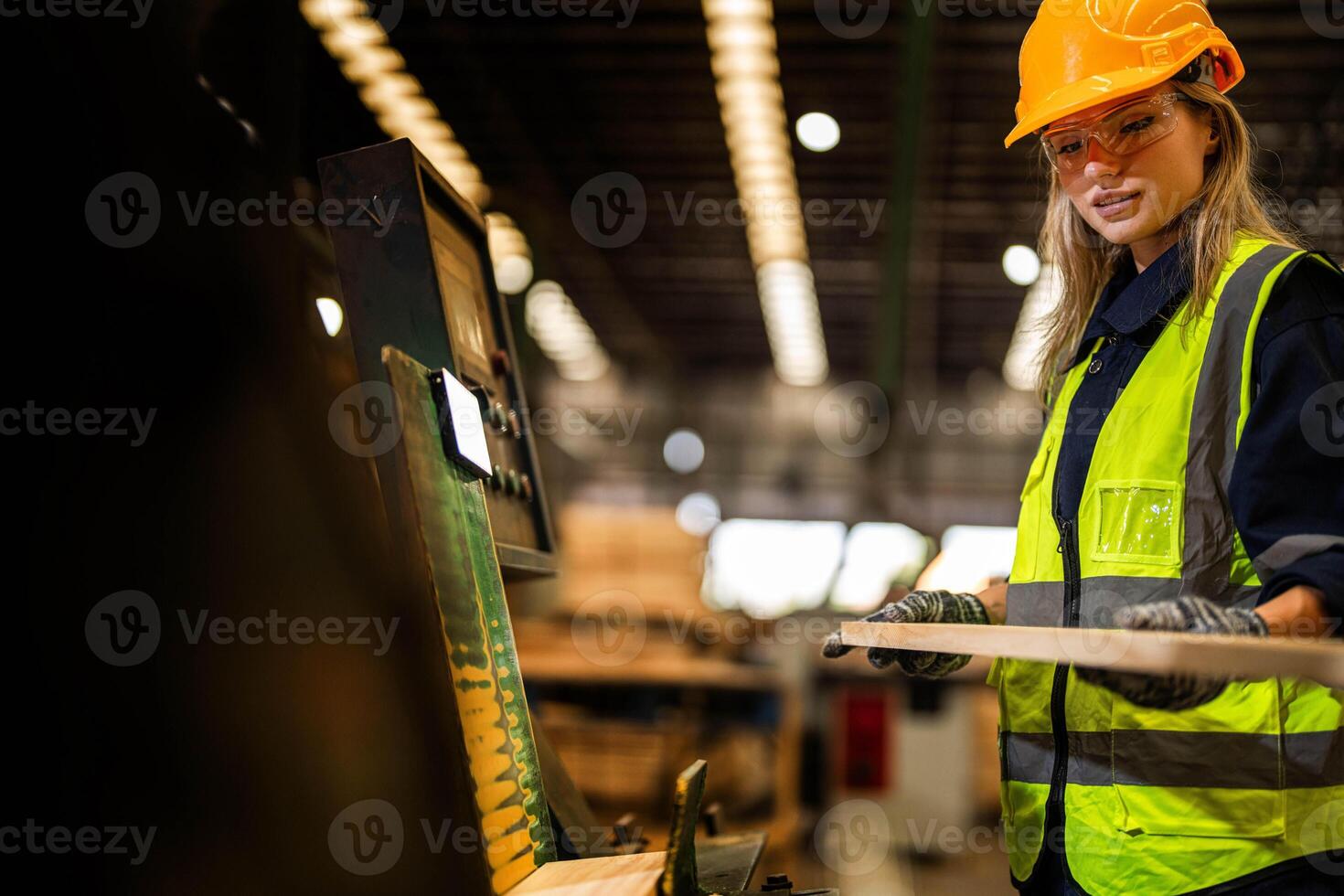 Factory engineer woman standing confident to control panel switch. Worker works at heavy machine at industry factory. worker checking timber of raw wood material. smart industry worker operating. photo