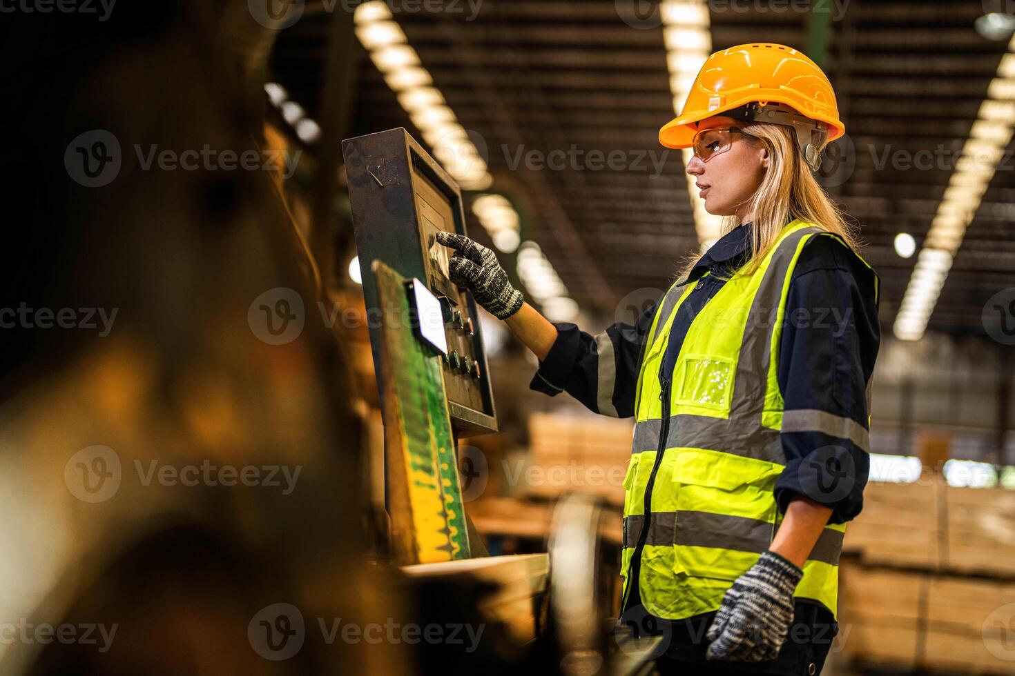 Factory engineer woman standing confident to control panel switch. Worker works at heavy machine at industry factory. worker checking timber of raw wood material. smart industry worker operating. photo