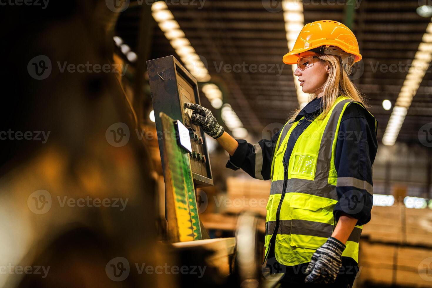 Factory engineer woman standing confident to control panel switch. Worker works at heavy machine at industry factory. worker checking timber of raw wood material. smart industry worker operating. photo