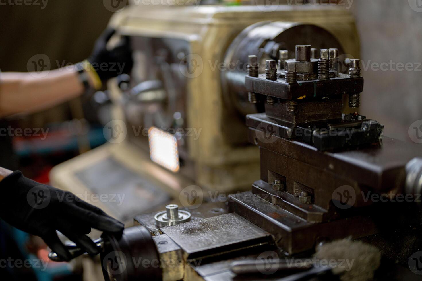 close up hand operation for Metal Lathes. steel column rolling in machine. metalworking industry. worker hand checks mechanic engine. Technician repairing drill bit on metal machine in factory photo