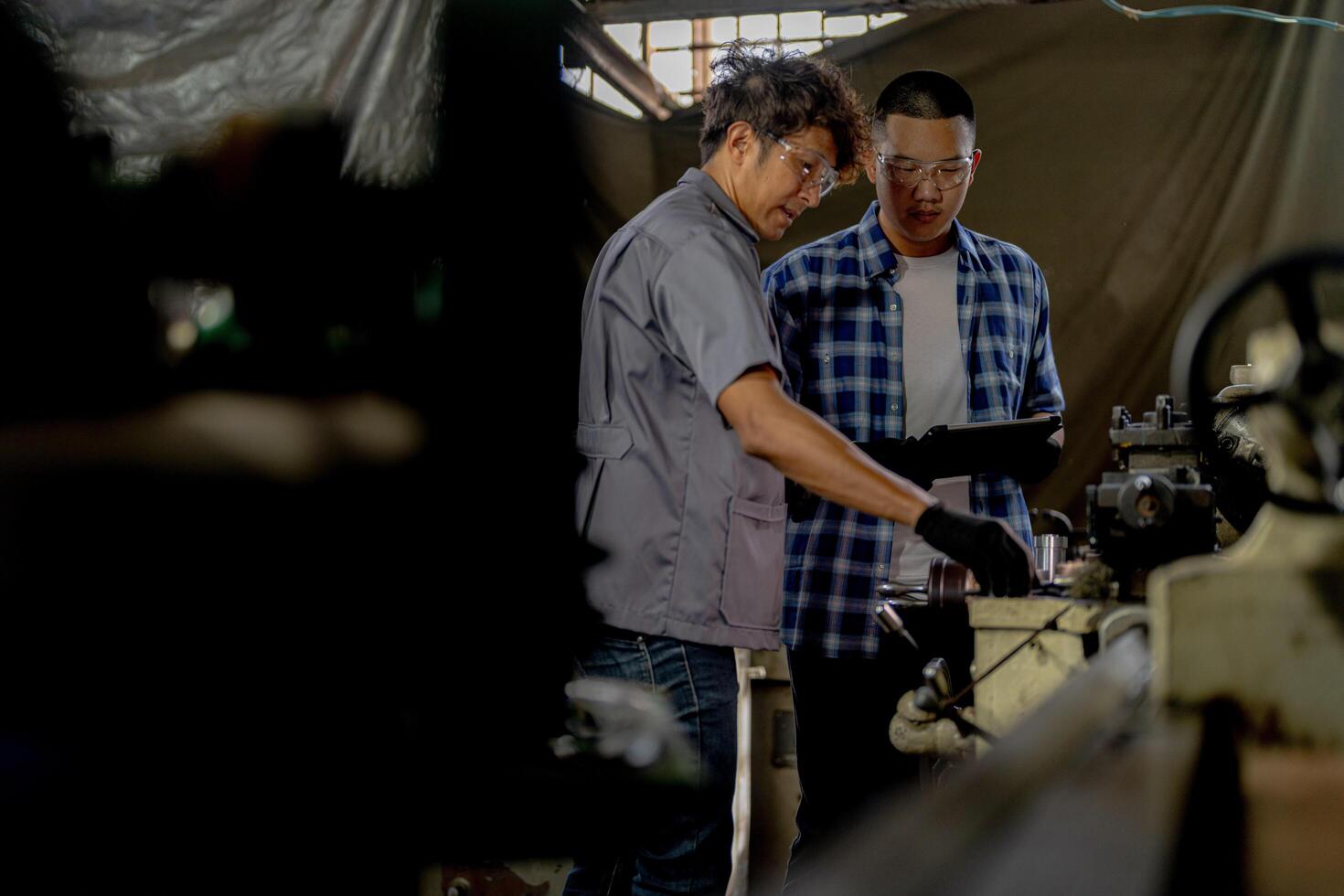 Men are inspecting steel parts for machine installation. team of teacher and student are learning to use heavy machines in steel factory. workers cooperate while doing quality control of manufactured. photo