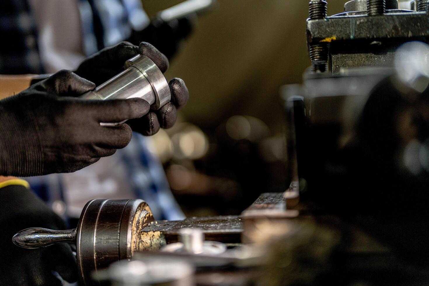 close up hand operation for Metal Lathes. steel column rolling in machine. metalworking industry. worker hand checks mechanic engine. Technician repairing drill bit on metal machine in factory photo