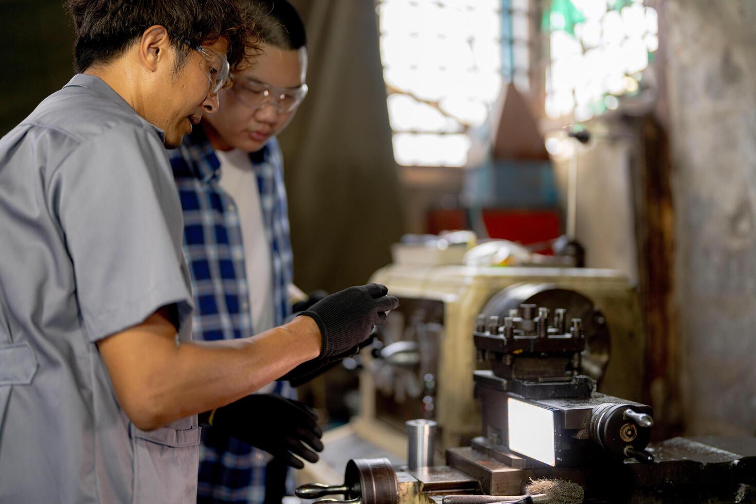 Men are inspecting steel parts for machine installation. team of teacher and student are learning to use heavy machines in steel factory. workers cooperate while doing quality control of manufactured. photo