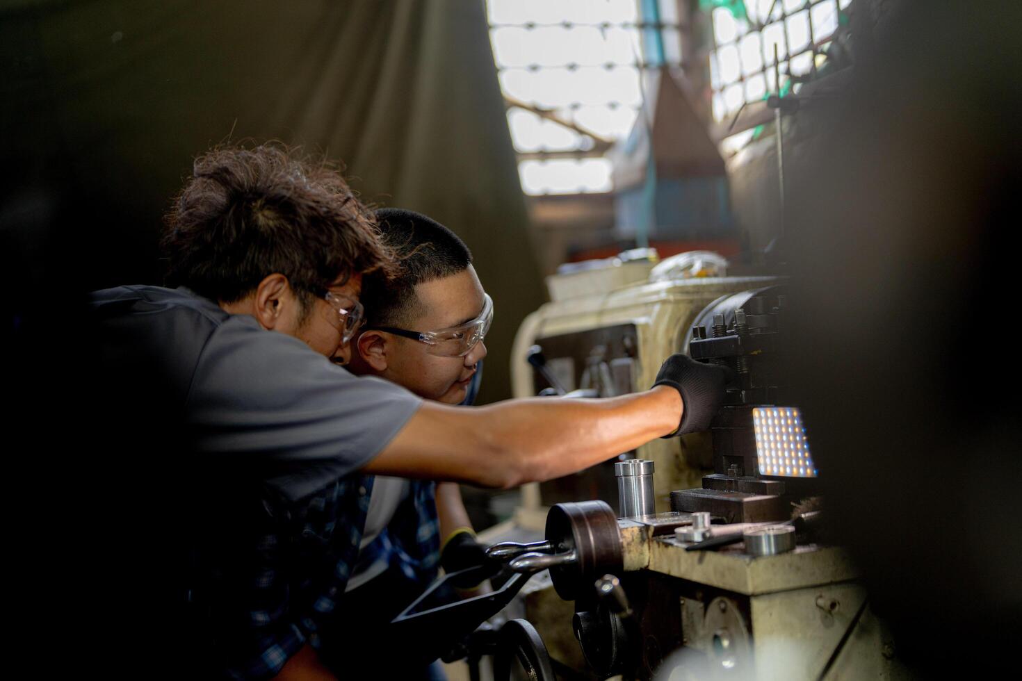 Men are inspecting steel parts for machine installation. team of teacher and student are learning to use heavy machines in steel factory. workers cooperate while doing quality control of manufactured. photo