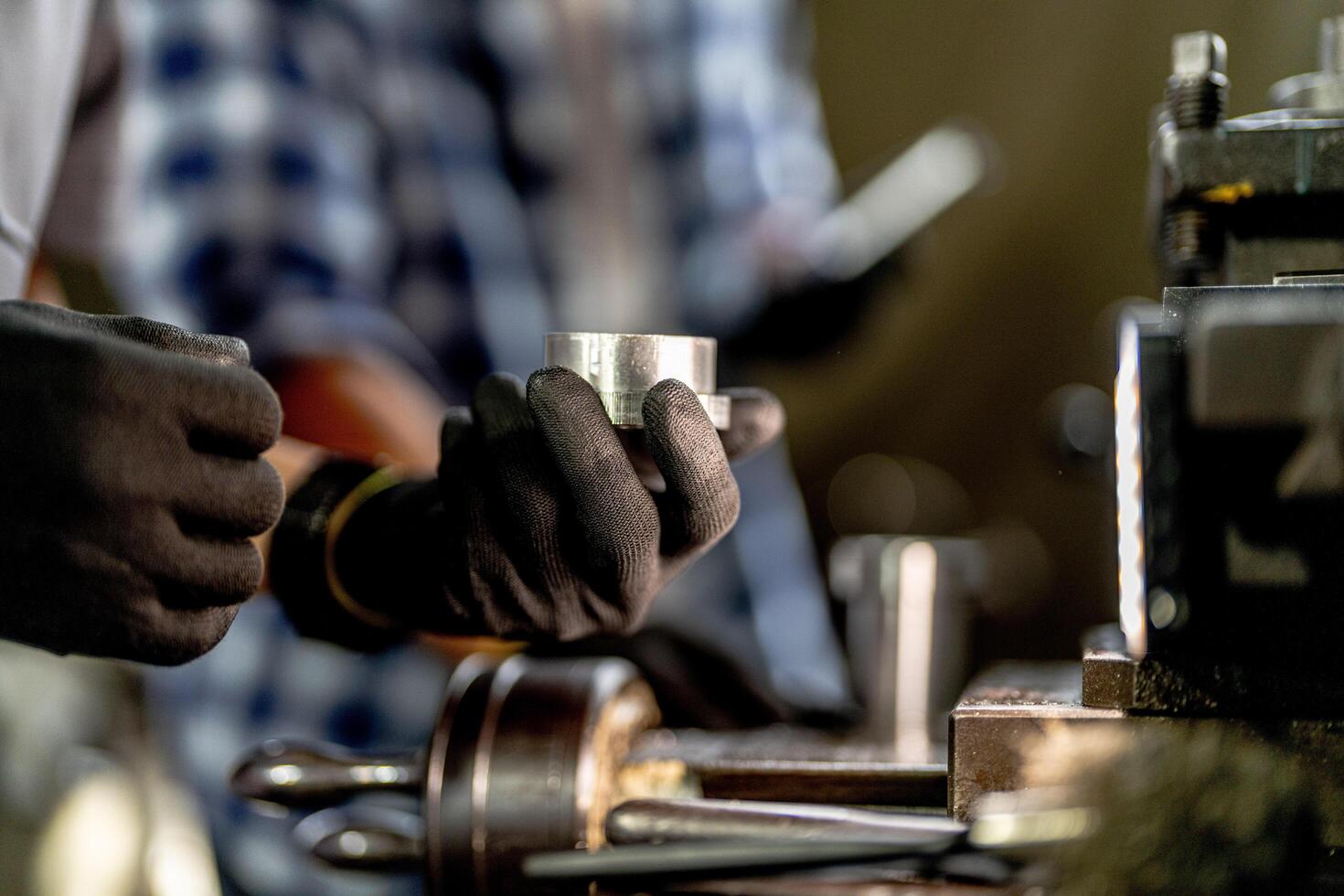 close up hand operation for Metal Lathes. steel column rolling in machine. metalworking industry. worker hand checks mechanic engine. Technician repairing drill bit on metal machine in factory photo