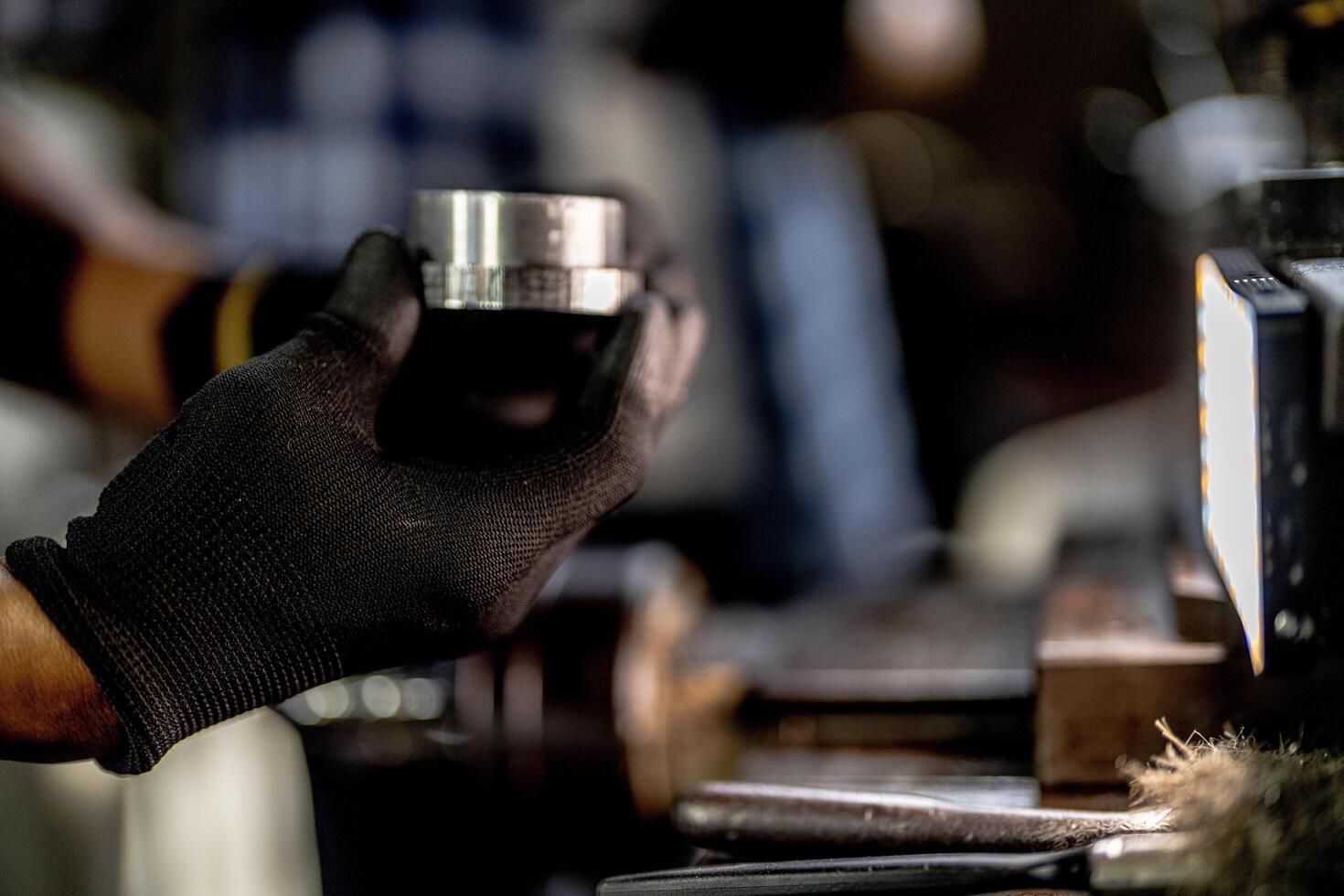 close up hand operation for Metal Lathes. steel column rolling in machine. metalworking industry. worker hand checks mechanic engine. Technician repairing drill bit on metal machine in factory photo