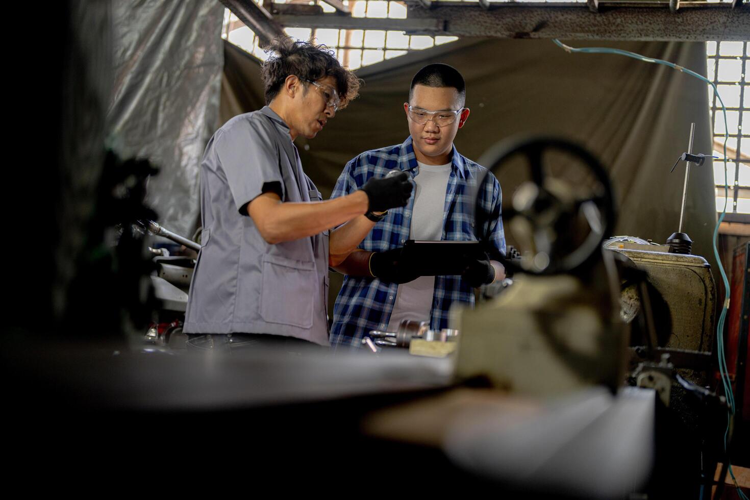 Men are inspecting steel parts for machine installation. team of teacher and student are learning to use heavy machines in steel factory. workers cooperate while doing quality control of manufactured. photo