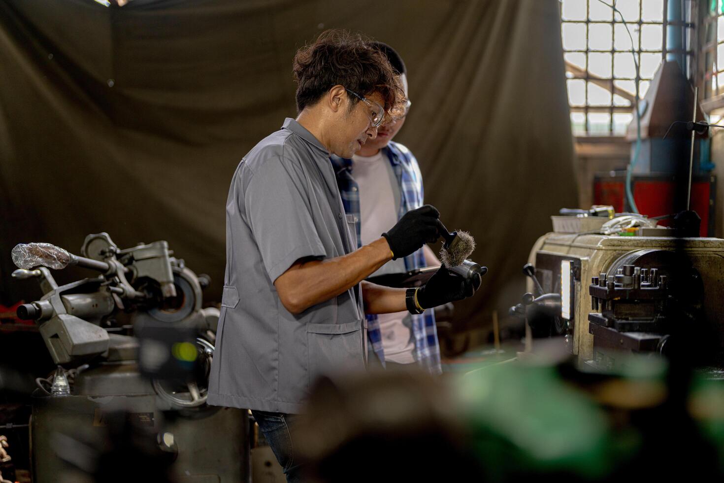 Men are inspecting steel parts for machine installation. team of teacher and student are learning to use heavy machines in steel factory. workers cooperate while doing quality control of manufactured. photo