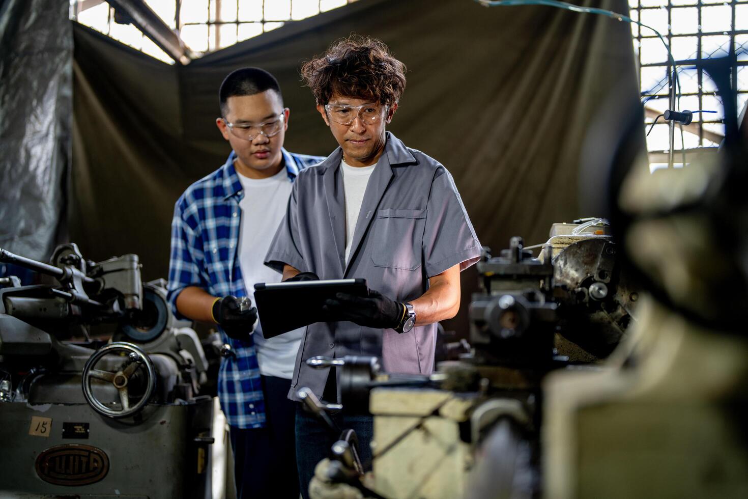 Men are inspecting steel parts for machine installation. team of teacher and student are learning to use heavy machines in steel factory. workers cooperate while doing quality control of manufactured. photo
