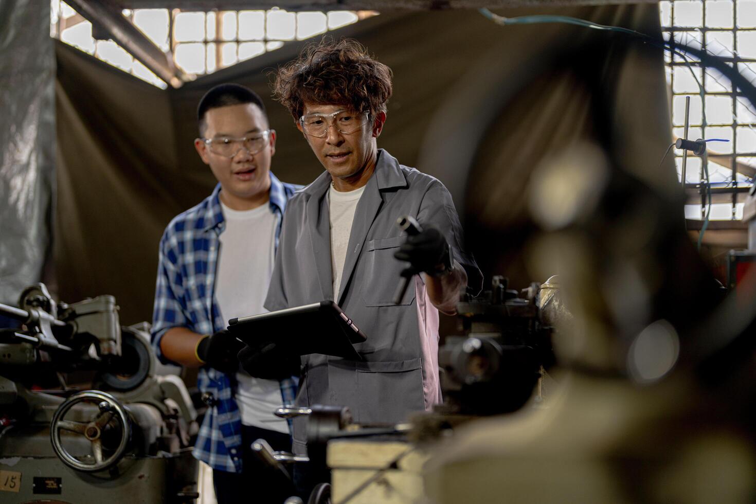 Men are inspecting steel parts for machine installation. team of teacher and student are learning to use heavy machines in steel factory. workers cooperate while doing quality control of manufactured. photo