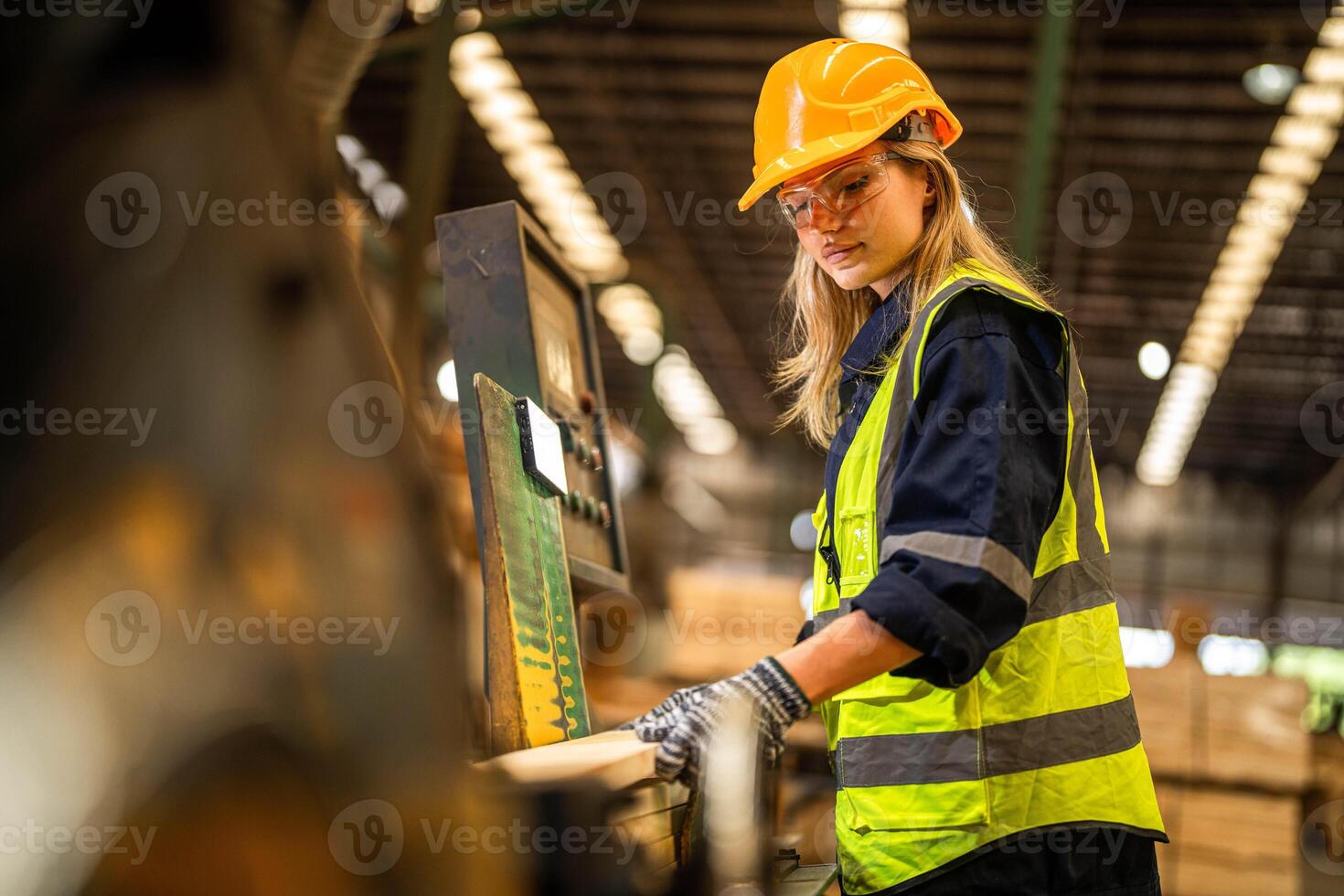 Factory engineer woman standing confident to control panel switch. Worker works at heavy machine at industry factory. worker checking timber of raw wood material. smart industry worker operating. photo