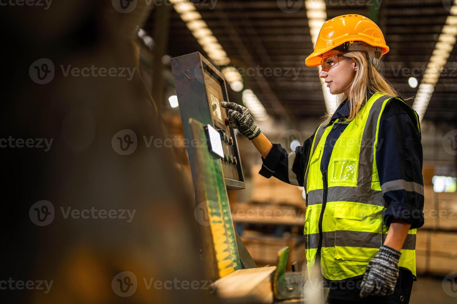 Factory engineer woman standing confident to control panel switch. Worker works at heavy machine at industry factory. worker checking timber of raw wood material. smart industry worker operating. photo