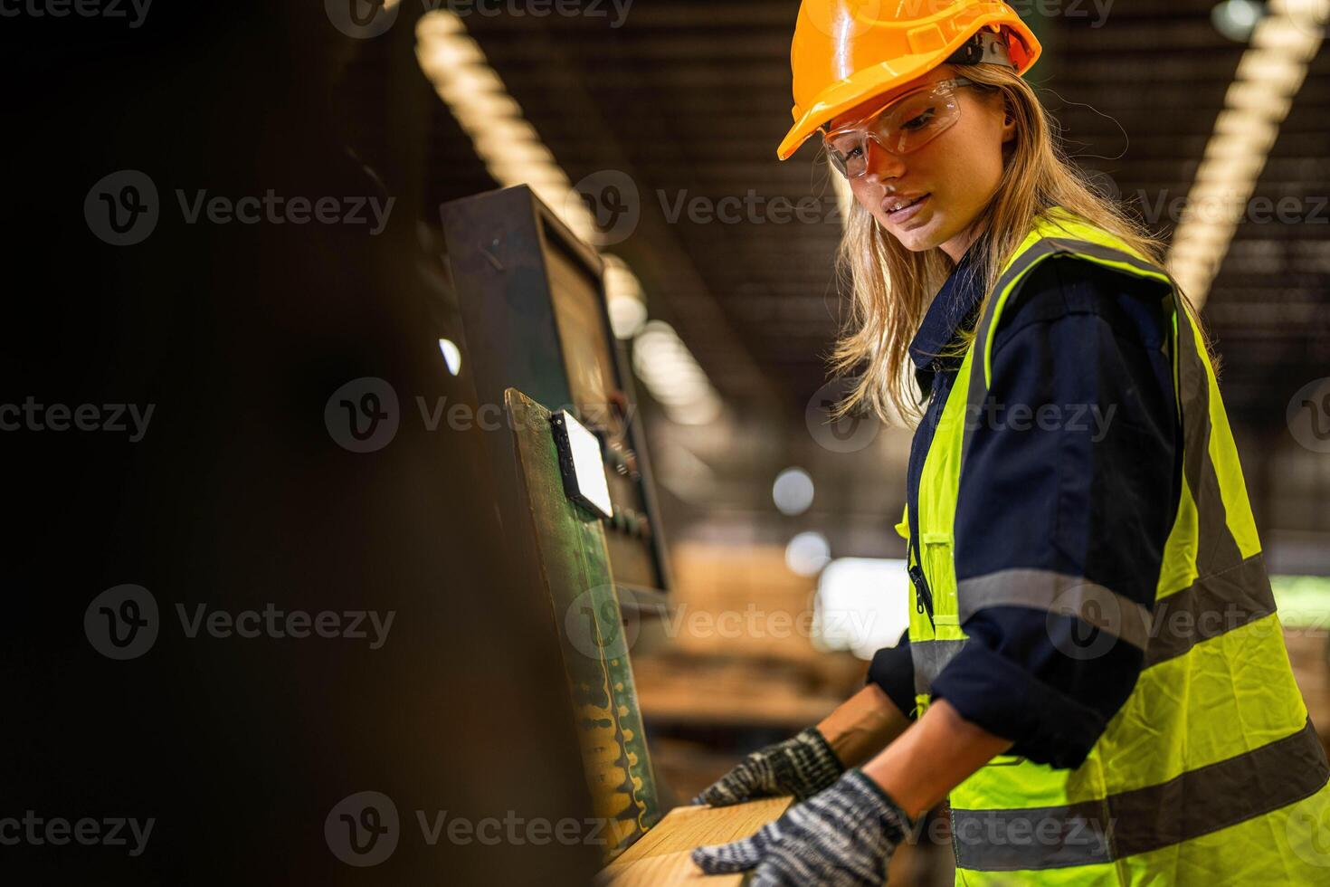 Factory engineer woman standing confident to control panel switch. Worker works at heavy machine at industry factory. worker checking timber of raw wood material. smart industry worker operating. photo